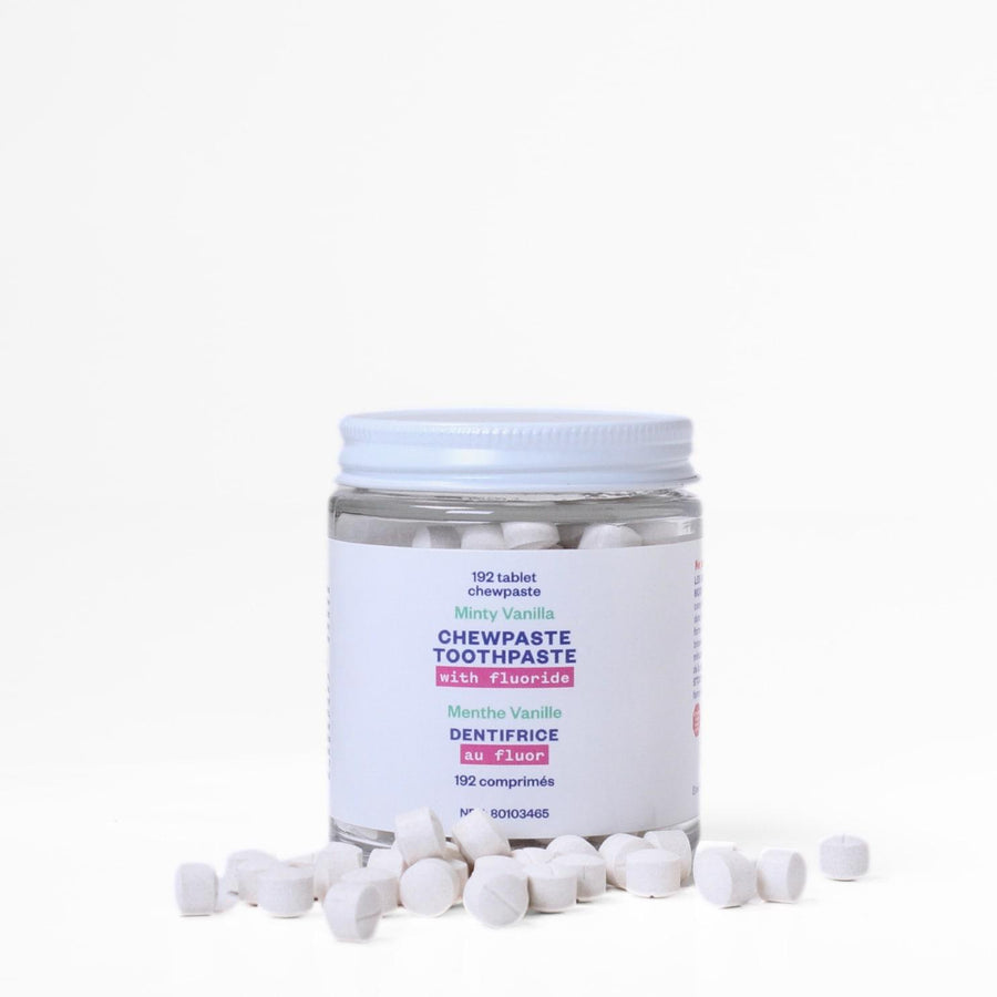 One tub of etee fluoride chewpaste stacked on top of each other with about 20 chewpaste tablets strewn in front of the jars